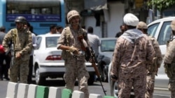 Members of the Islamic Revolutionary Guards Corps secure the area outside the Iranian parliament during an attack on the complex in Tehran on June 7.