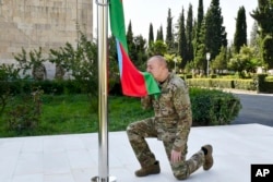 На знімку жовтня 2023 року: президент Азербайджану Ільгам Алієв цілує прапор своєї країни в місті Агдара, яке в Нагірному Карабаху раніше перебувало під контролем Вірменії