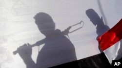 Тіні хуситських повстанці в Ємені на тлі прапору країни (ілюстраційне фото) 