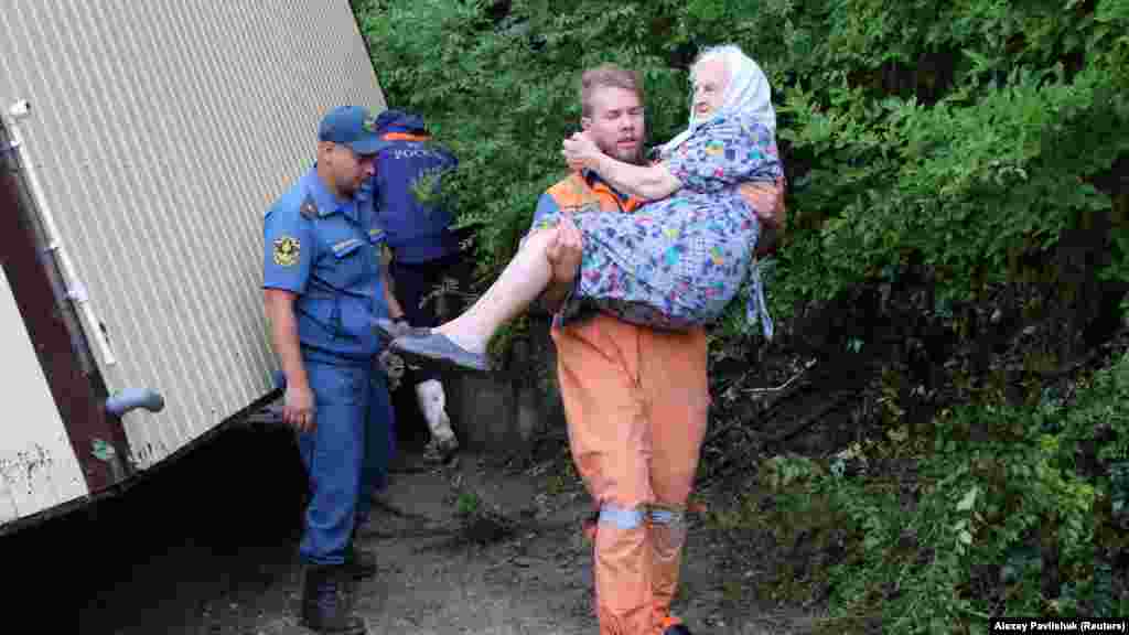 Из всех населенных пунктов Бахчисарайского района поселок Куйбышево во время ливней, которые прошли 4 июля в горах, пострадал больше всего.&nbsp; На фото: спасатель несет на руках пожилую женщину после затопления