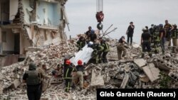 Спасителни екипи извеждат тяло на убит в ракетния удар, нанесен от руската армия по жилищна сграда. Часов яр, Донецка област, Украйна, 10 юли 2022 г.