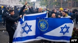 Прихильники «Маккабі Тель-Авів» тримають прапори на площі Дам перед футбольним матчем Ліги Європи в Амстердамі, 7 листопада 2024 року