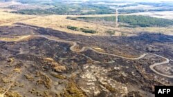 Тази въздушна снимка от 12 април показва последствията от горския пожар в 30-километровата забранена зона край Чернобил, Украйна, недалеч от едноименната атомна електроцентрала