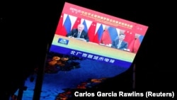 На гигантском экране торгового центра в Пекине транслируются новости о виртуальной встрече президента Китая Си Цзиньпина с российским коллегой Владимиром Путиным. 15 декабря 2021 г.