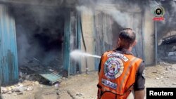 Një pjesëtar i shërbimeve të emergjencës shuan zjarrin në një shtëpi në Han Junis, Gazë, 23 maj 2025.