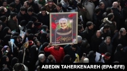 Ožalošćeni nose sliku ubijenog iranskog generala Kasema Sulejmanija tokom pogrebne povorke u Bagdadu