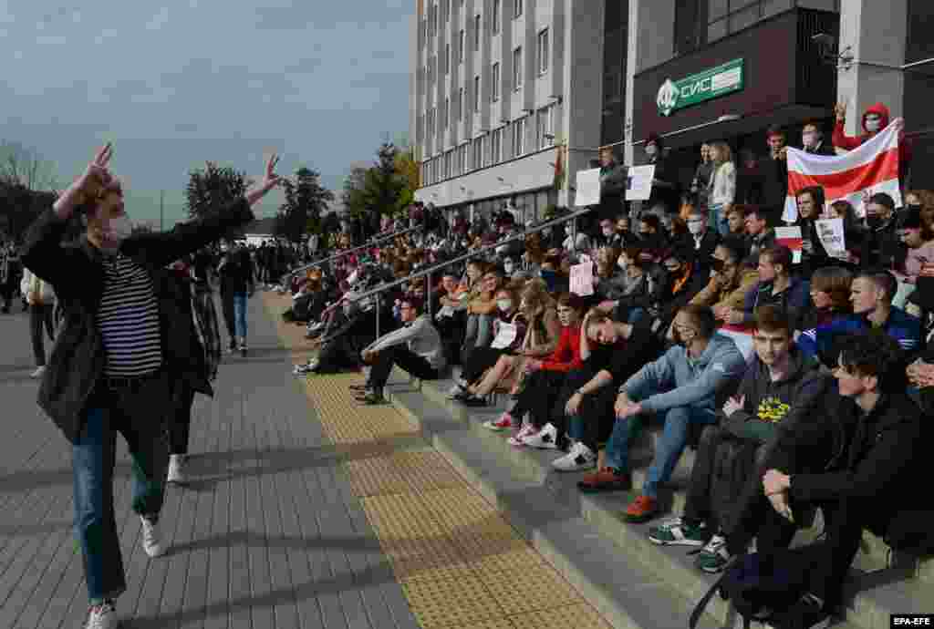 A győzelem jelét mutatják a diákok az egyetem épülete előtt.