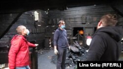 Parohul Bisericii Arhanghelul Mihail, Andrei Ioan Danciu, ajutat de câțiva voluntari, în mijlocul bisericii, după incendiul din 28 octombrie 2020.