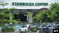 Indonesia -- Plainclothes police aim their handguns towards suspects outside a cafe after a series of blasts hit the Indonesia capital Jakarta, January 14, 2016
