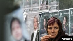 Stanovnica srpskog dela Gnjilana pored predizbornih plakata na pijaci u Gnjlanama, 2. decembar 2010