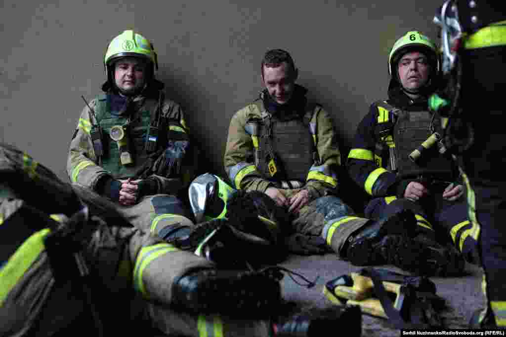 Рятувальники, які займалися ліквідацією пожежі, відпочивають у дворі
