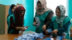Afghan election officials count ballot papers after polls closed in Kabul on June 14.