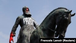 Graffiti pe statuia fostului rege belgian Leopold al II-lea de lângă Palatul Regal din Bruxelles, Belgia, 10 iunie 2020. 