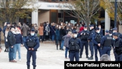 Njerëzit janë mbledhur pranë shkollës ku ndodhi sulmi. 17 tetor, 2020.
