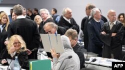 Az egyik vádlott eltakarja az arcát a bíróságon, Frankfurtban 2024. május 21-én