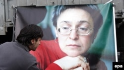 A Russian man lays flowers near the picture of murdered journalist Anna Politkovskaya during a rally in Moscow on the anniversary of her death in 2009.