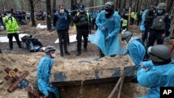 Uposlenici hitne pomoći premještaju tijelo tokom ekshumacije u Izjumu, 16. septembra 2022.