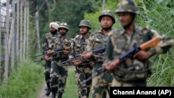 Indian Border Security Force (BSF) soldiers patrol near the India Pakistan border fencing at Garkhal in Akhnoor, about 35 kilometers west of Jammu on August 13.