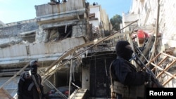Члени сирійських сил безпеки стоять біля пошкодженого місця після того, як Ізраїль завдав авіаудару по сирійській столиці Дамаск у четвер