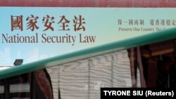 Kormányhirdetés népszerűsíti az új nemzetbiztonsági törvényt Hongkongban a törvényhozás épületénél 2020. június 29-én