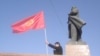 Архівна світлина. Чоловік із киргизьким прапором біля пам'ятника Володимиру Леніну в центрі міста Ош. Міська влада зняла цей пам'ятник у червні