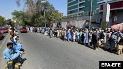 Afgánok tömegei állnak sorban, hogy pénzt vegyenek fel a bankokból, amelyek heti kétszáz dolláros limitet vezettek be. Kabul, 2021. szeptember 1.