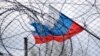 Generic – The flag of Russia on the background of the fence and barbed wire