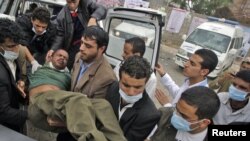 Medics carry an injured antigovernment protester into a makeshift clinic in Sanaa on March 13.