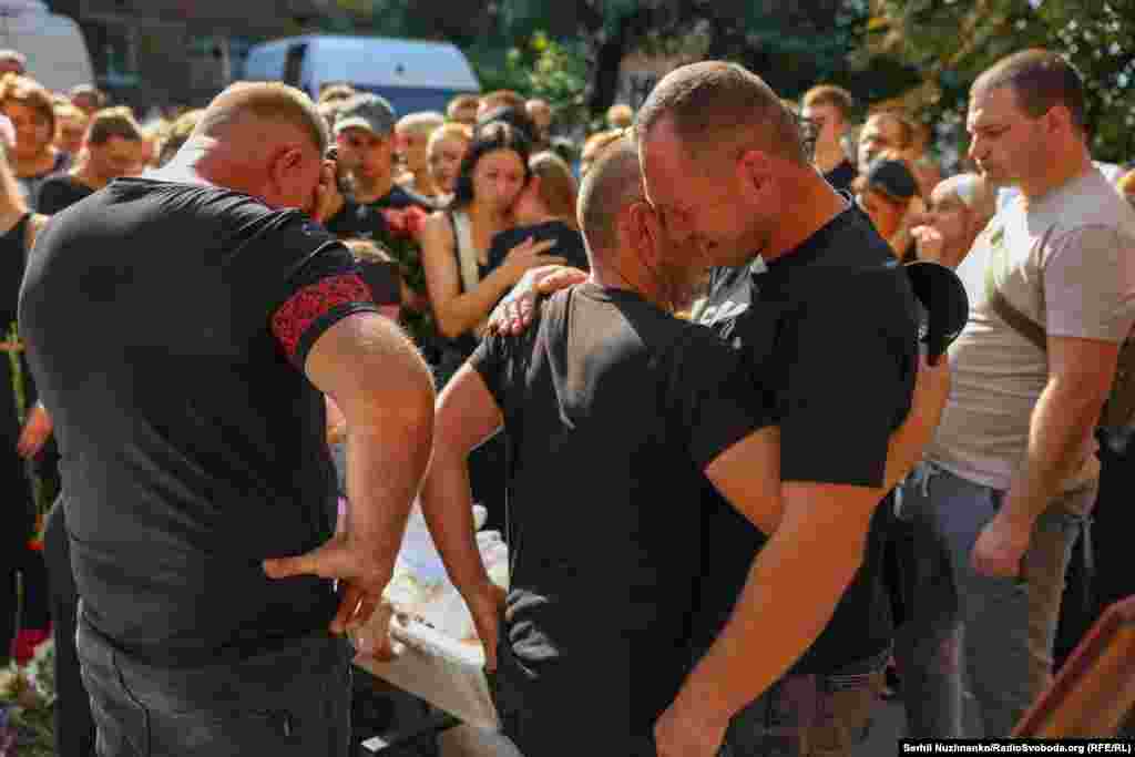 Батько Надії і її чоловік плачуть біля трун своїх рідних загиблих, які стали жертвами атаки РФ на Київ у ніч проти 28 серпня. Фото від 31 серпня 2025 року