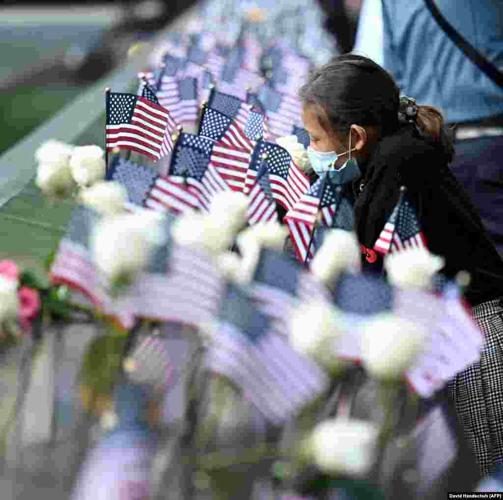 Një vajzë vendos flamuj dhe lule në Memoralin për viktimat e sulmeve të 11 shtatorit në Nju Jork.&nbsp; 