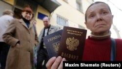Nő a régi ukrán és az új orosz útlevelével az annektált Krím félszigeten lévő Szimferopolban 2014. április 7-én