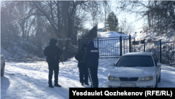 Нурганат Гайыпбаев менен Шерзат Полаттын сөөгү коюлган көрүстөндүн жанында куралчан полиция кызматкерлери турат. Алматы облусу. 11-декабрь, 2024-жыл.
