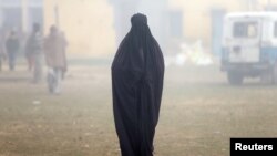 Бурка же паранжы кийип жургөн аял.