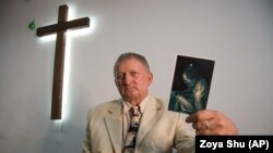 Євангельський пастор Віталій Параскун тримає свою фотографію, зроблену після звільнення з полону в Луганській області, де, за його словами, був захоплений бандою «казаків» у жовтні 2014 року під час місіонерської роботи