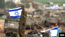 سربازان اسرائیلی پرچم به دست به مرزهای اسرائیل به نوار غزه بازمی گردند. (عکس: Afp)