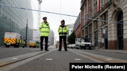 Police stand in the vicinity of Manchester Arena where a deadly bomb attack killed 22 people on May 22.
