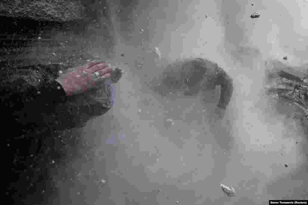 Syrian rebels dodge debris after the wall which they were taking cover behind is hit by a shell fired from a government-controlled checkpoint during fighting in the Ein Tarma neighborhood of Damascus, Syria, January 30, 2013. (Reuters/Goran Tomasevic)