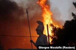 Athéné istennő szobra, a háttérben Varimpompi lángol, Athéntól északra, 2021. augusztus 3-án