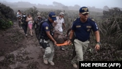 Поліція із пораненим чоловіком після виверження вулкана Фуего, село Ель Родео, Гватемала, 3 червня 2018 року