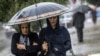 Two women try to keep dry in an autumn rainfall in Rasht, Iran.