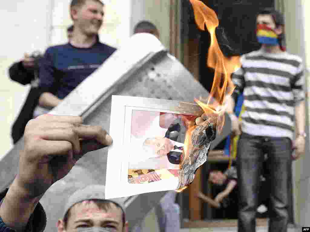 MOLDOVA, REPUBLIC OF, CHISINAU : Protestors burn a Picture of Moldovan President Vladimir Voronin near the presidential building in central Chisinau on April 7, 2009. Over 30 people including both protestors and police were injured in protests against the results of Moldovan legislative elections, the head doctor at Chisinau's emergency hospital