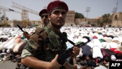 Borac Prijelaznog nacionalnog vijeća stoji i čuva vjernike dok se mole u petak popodne na Trgu palih boraca u Tripoliju, 02. septembar 2011.