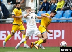 Қазақстан ойыншылары (сары форма киген) әлем кубогына іріктеу кезеңде Солтүстік Македонияға қарсы ойнап жатыр. Астана, 9 маусым, 2025 жыл.