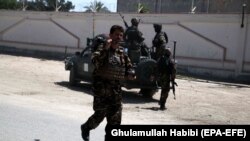 Afghan security officers stand guard outside the residence of Faridoon Momand, an Afghan lawmaker, after a suicide bomb attack in Jalalabad on June 8.