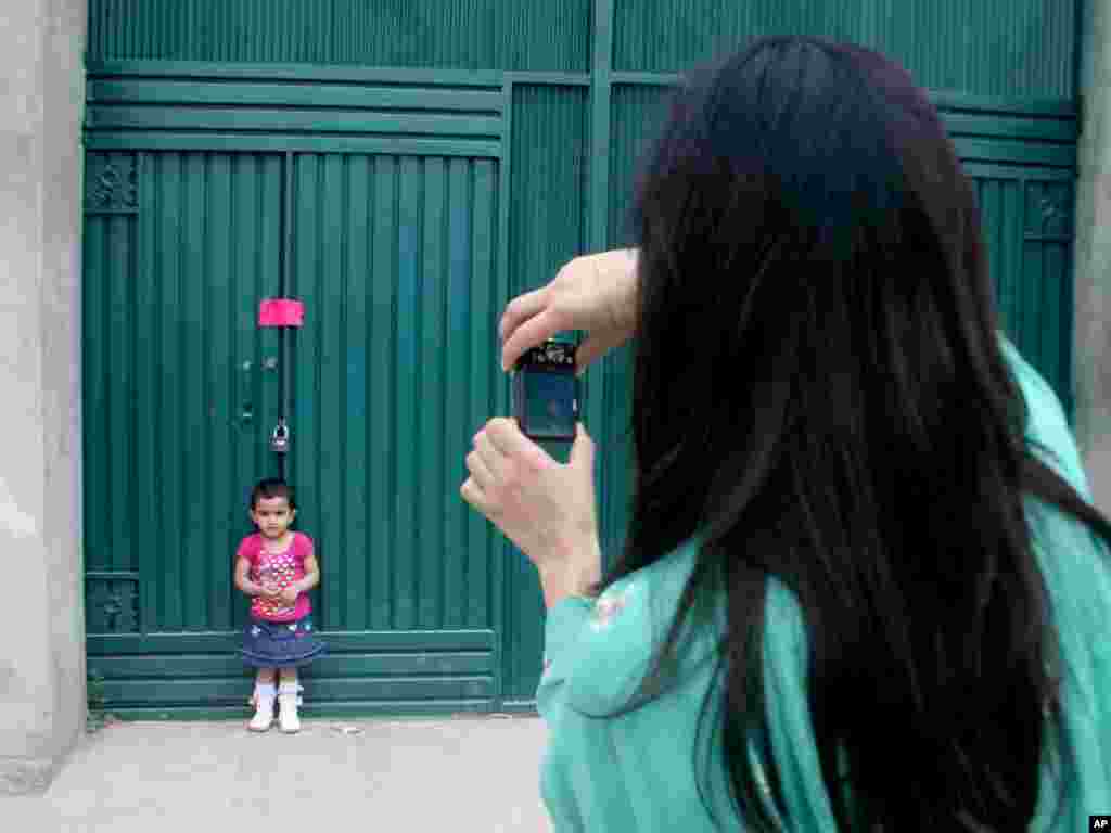 Исторический снимок в Абботтабаде. - Именно здесь, в этом дворе, где мама фотографирует свою дочь, была совершена специальная операция по поимке и убийству Усамы бин Ладена. Фото AP.       