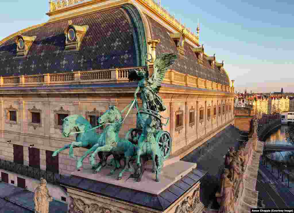 Ника, божица на победата, прикажана како тера кочија со три коњи на аголот на Народниот театар. Иконската статуа на покривот е всушност копија на оригиналот. Веднаш откако Бохуслав Шнирх ги заврши бронзените скулптури на театарот по неколку години работа, тој гледаше како беа уништени од пожарот во 1881 година. Копиите беа поставени на реконструираната зграда во 1911 година, една деценија по смртта на Шнирх.