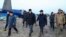 Members of an investigation committee and local officials walk past the wreckage of Azerbaijan Airlines' Flight J2-8243, which crashed in Aqtau in western Kazakhstan the previous day, killing dozens. 