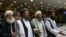 FILE: Mullah Abdul Ghani Baradar, the Taliban group's top political leader, second from left, arrives with other members of the Taliban delegation for talks in Moscow in May.