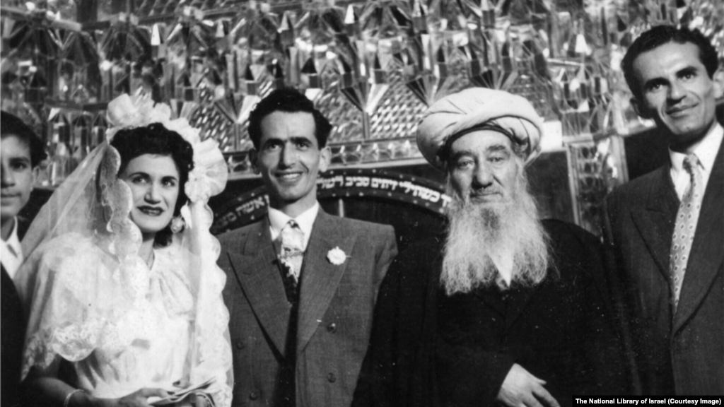 برگزاری یک عروسی یهودی در دههٔ ۱۹۵۰ در مکانی نامشخص در ایران. این مراسم توسط حاخام شلومو کهن صدیق (وسط سمت راست)، رهبر روحانی یهودیان کشور، برگزار شد.نوشته عبری پشت گروه به فرازی از کتاب مقدس یهودیان اشاره دارد: «همسرت مانند تاک بارور در درون خانه‌ات باشد، و فرزندانت مانند جوانه‌های زیتون در اطراف سفره‌ات».