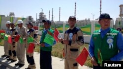 Рабочие с государственными флагами Китая и Туркменистана на церемонии запуска газового месторождения Галкыныш, 4 сентября 2013 г. 